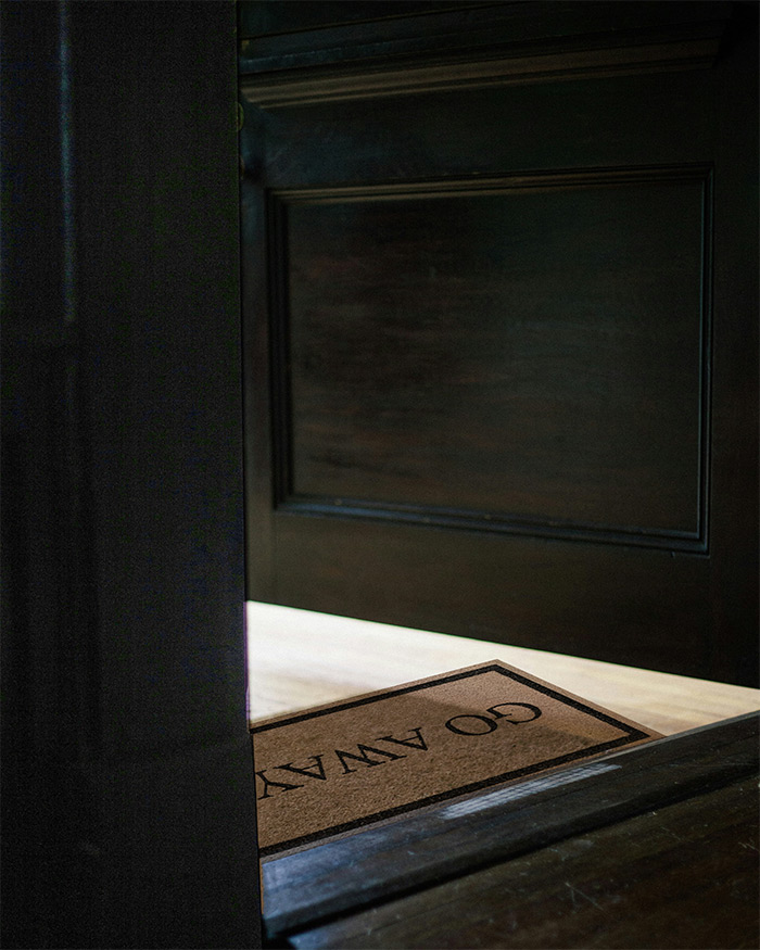 a doormat with the words go away is placed in from of a door to anchor a home protection spell