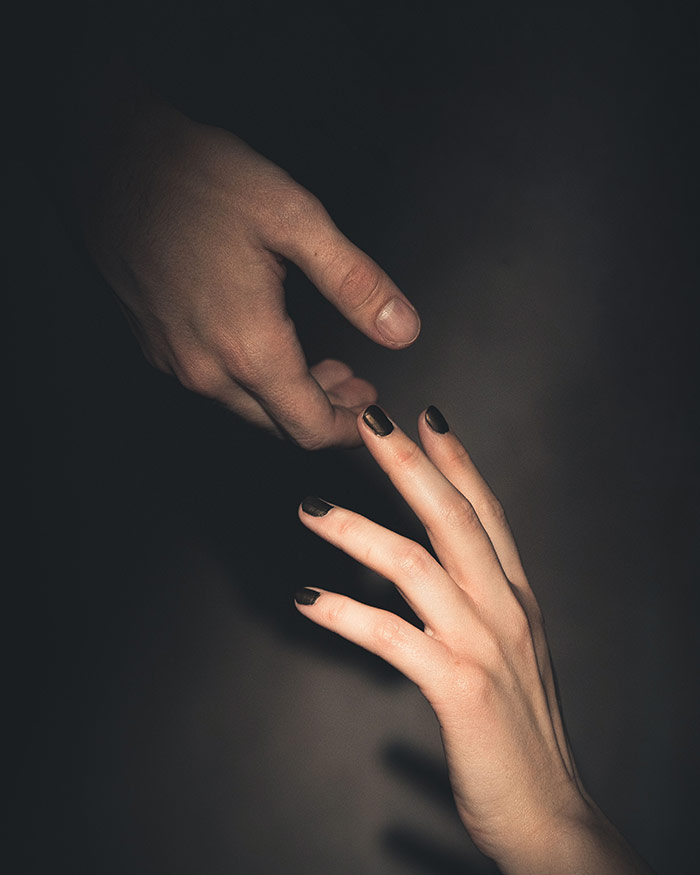 two hands reaching for each other