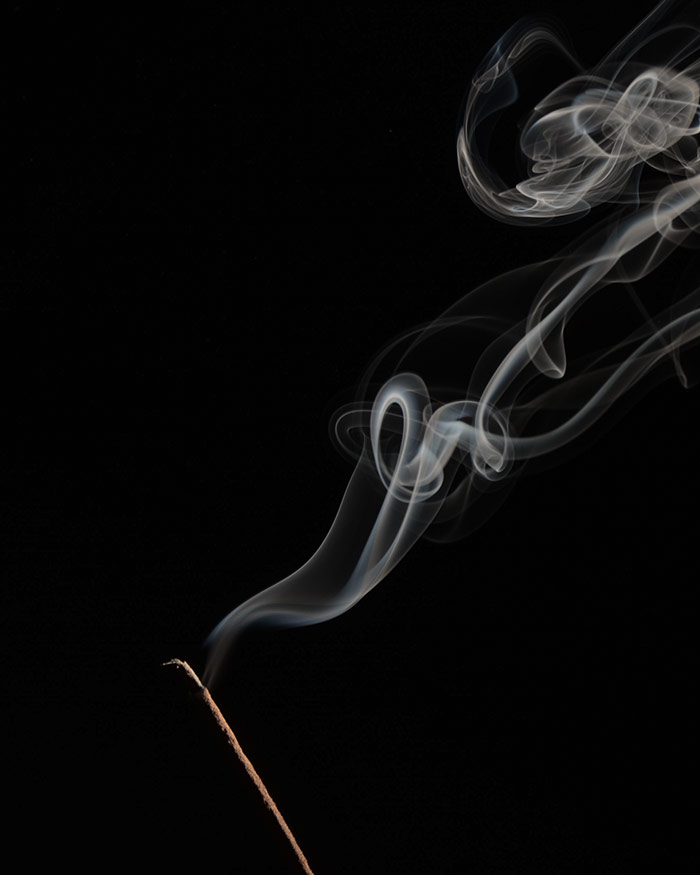 cleansing smoke comes from and incense stick shown in the darkness