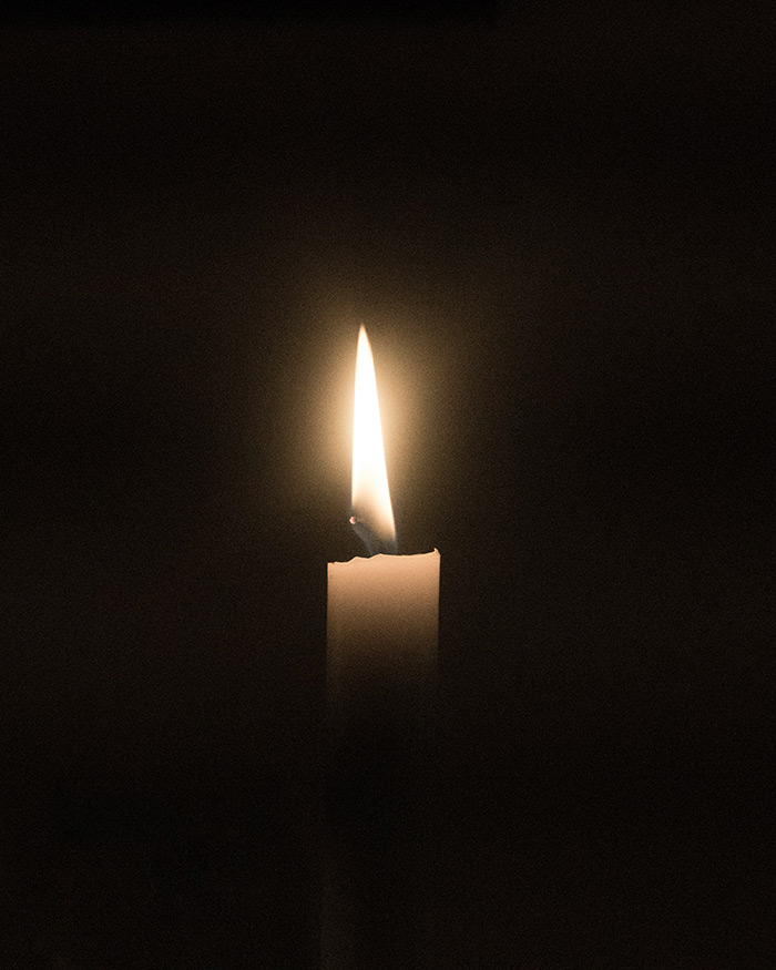 white candle lit in the dark