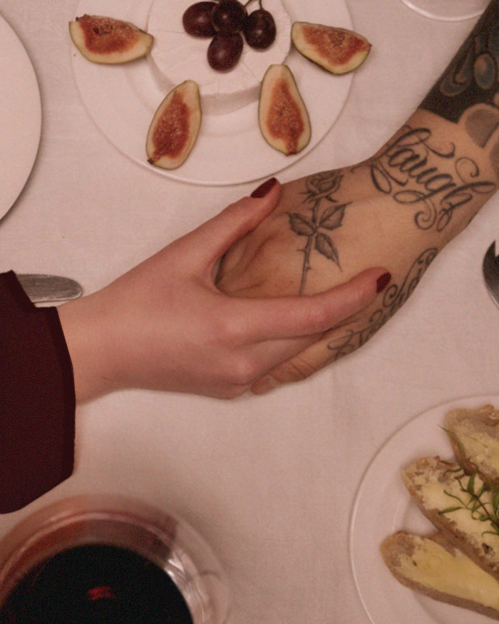 a man and a woman hold hands across a dinner table embracing over the success of the attract new love spell