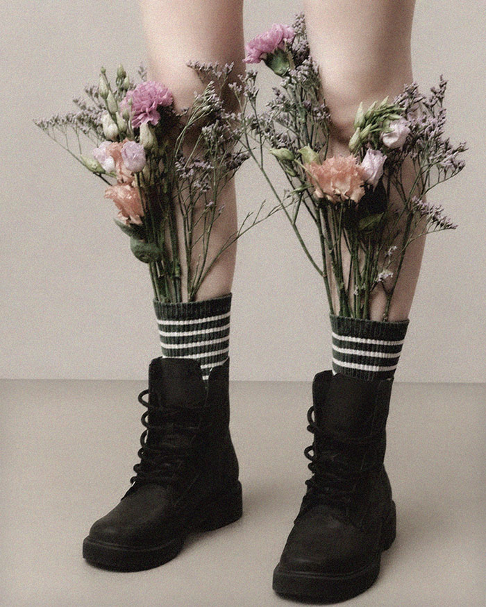 a woman stands strong in boots with flowers poking out symbolizing the confidence spell jar
