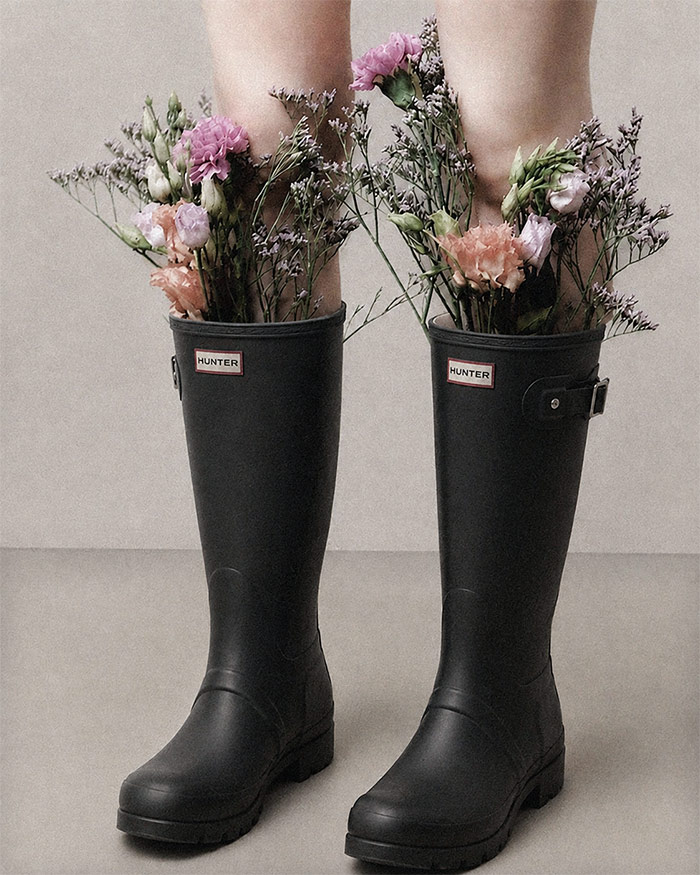 a woman stands strong in boots with flowers poking out symbolizing the confidence spell jar