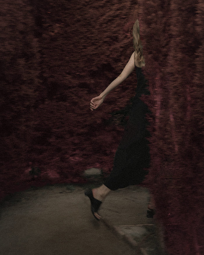 a woman in a black dress turns the corner of an open path created by a love road opener spell