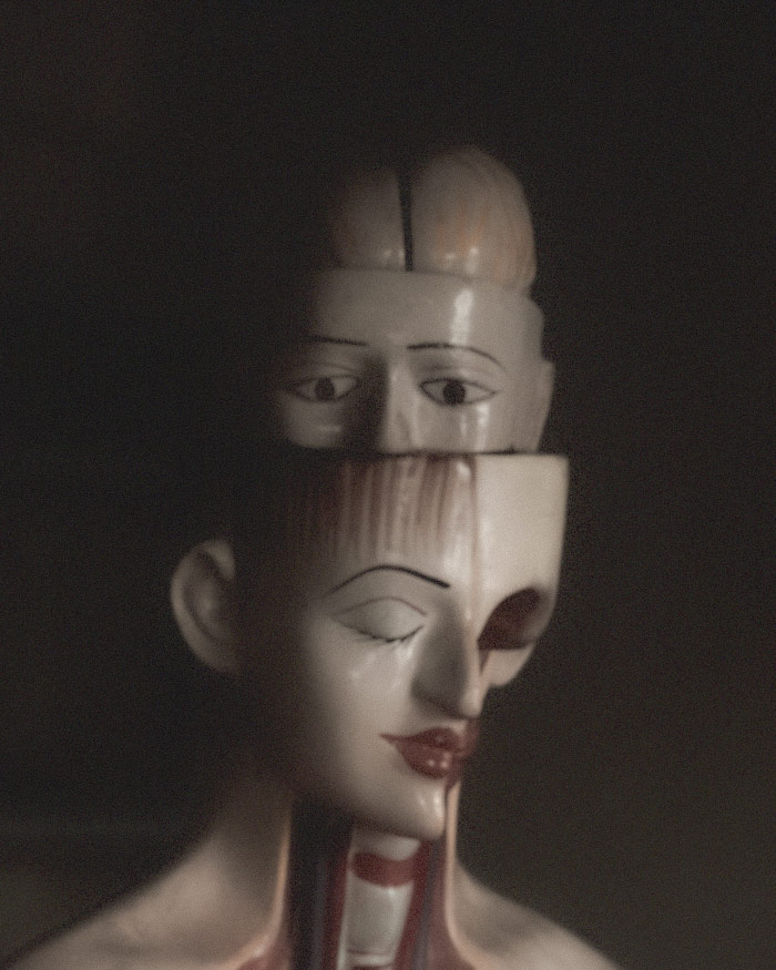 a ceramic figure showing a brain nested within a head that is nested within another head displaying an uncomfortable surreal dream state causing the need for a nightmare protection sachet